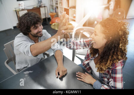 Co-workers  giving one another high five Stock Photo