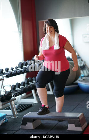 Overweight woman at the gym doing fitness exercises Stock Photo