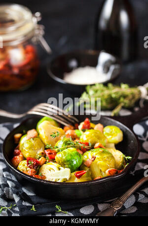 Roasted brussels sprouts with bacon and sun dried tomato in  pan Stock Photo
