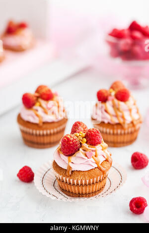 Delicious raspberry and caramel cupcakes on white background Stock Photo
