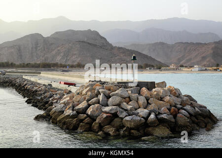 View on a little harbour in Oman during sunset, Al Hajar Mountains at the background Stock Photo