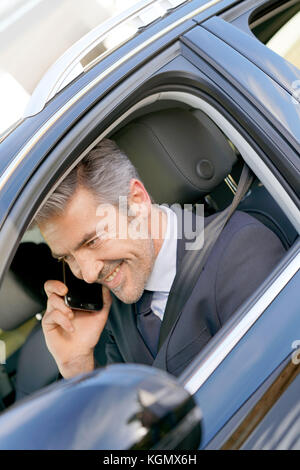 Private driver inside car talking on phone Stock Photo