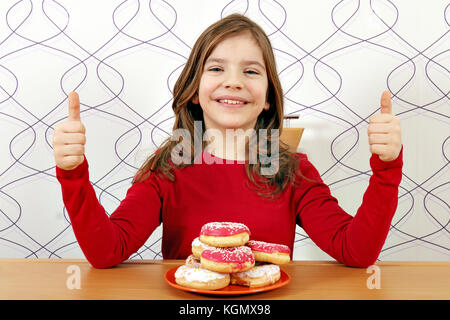 happy little girl with donuts and thumbs up Stock Photo