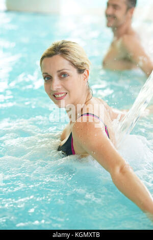 Woman enjoying water jet in thermal bath Stock Photo