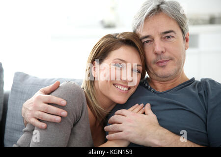 Middle-aged couple relaxing on sofa at home Stock Photo