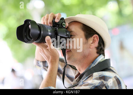 Professional photographer in town taking pictures Stock Photo