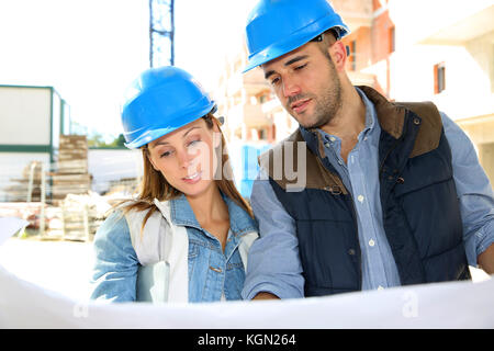 Engineers on building site reading blueprint Stock Photo