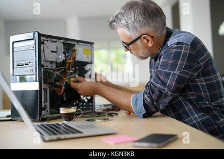 Technician repairing computer hardware Stock Photo