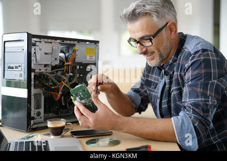 Technician repairing computer hardware Stock Photo