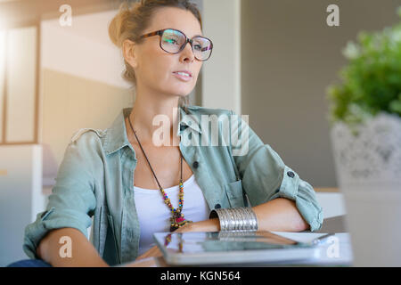 Trendy designer girl at home working on digital tablet Stock Photo