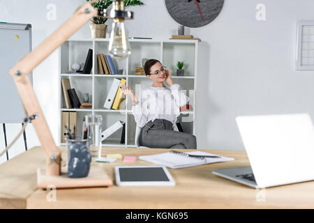 Businesswoman talking on phone in modern office Stock Photo