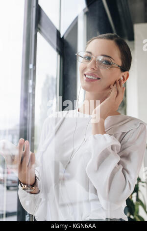 Smiling businesswoman in earphones  Stock Photo