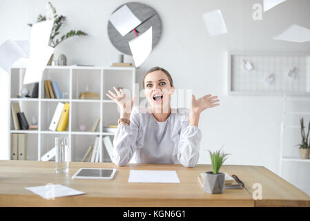 Cheerful businesswoman sitting at desk in office Stock Photo