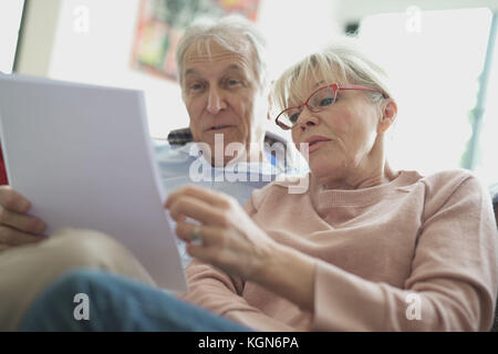 Senior couple in sofa reading official documents Stock Photo