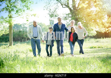 Happy family of 6 walking in park Stock Photo