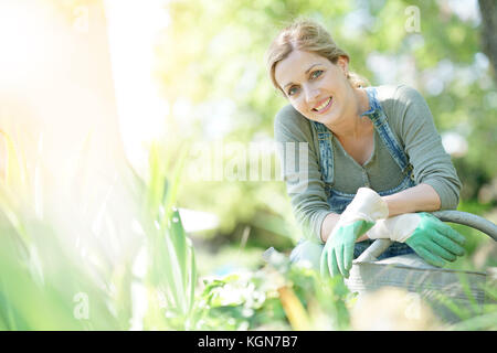 Smiling blond woman gardening Stock Photo