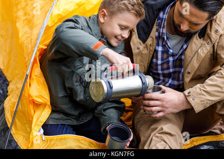 son with thermos in camping Stock Photo