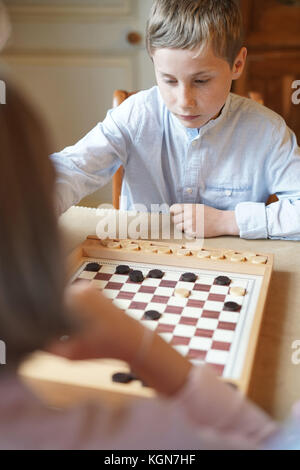Kids playing checkers at home Stock Photo