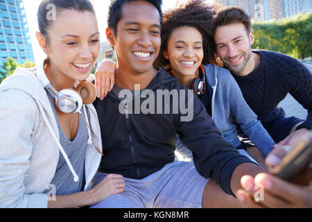 Group of friends in casual outfit taking selfie picture with smartphone Stock Photo