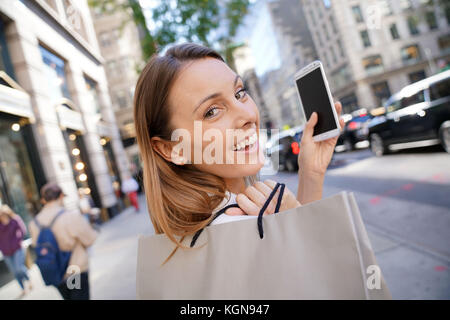 Cheerful girl shopping in Manhattan and talking on phone Stock Photo