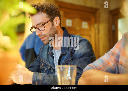 Young man in coffee shop connected on smartphone Stock Photo
