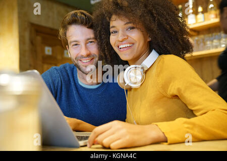 Couple in restaurant connected on internet with laptop Stock Photo