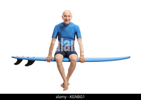 Elderly surfer sitting on a surfboard and smiling isolated on white background