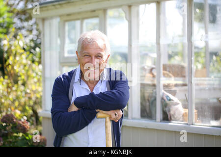 Cheerful senior man standing by greenhouse Stock Photo