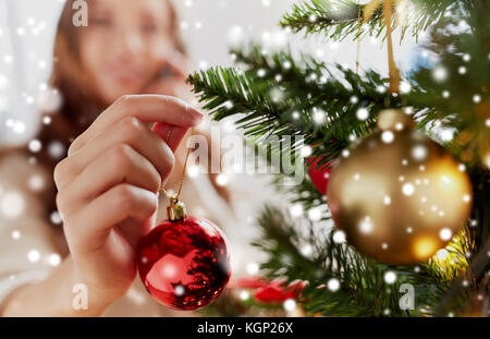 close up of woman hand decorating christmas tree Stock Photo