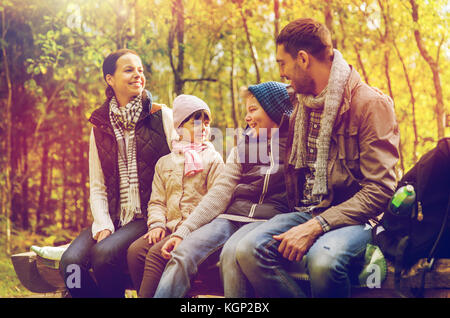 happy family sitting on bench and talking at camp Stock Photo