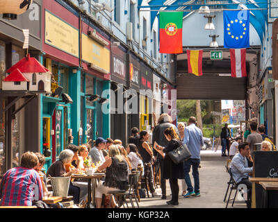 People eating at restaurants in Brixton Village in Brixton-  one of the most vibrant and multicultural parts London Stock Photo