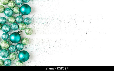 Beautiful, bright, modern, blue and green Christmas holiday ornaments decorations with sparkling glitter on white background. Horizontal border. Stock Photo