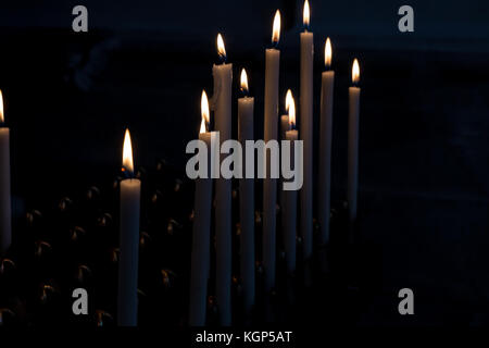 Detail of lit candles in the dark. Stock Photo