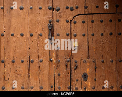 detail of ancient doorway within studded wooden door with knocker keyhole, lock and studs in Córdoba, Spain Stock Photo