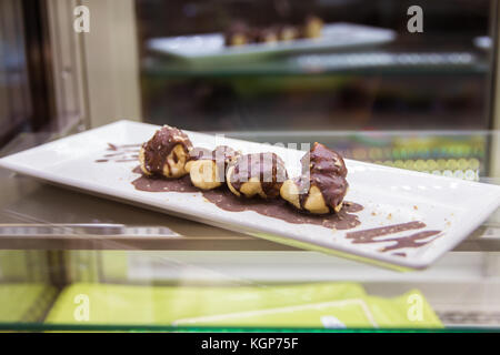 Chocolate cupcakes on plate on table Pouring chocolate sauce on piece of chocolate cake Stock Photo