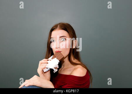 Close-up girl eating chocolate Bar Stock Photo