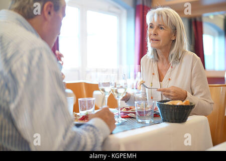 Senior couple sitting at restaurant table for dinner Stock Photo