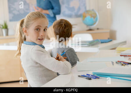 Portrait of schoolgirl taking notes in class Stock Photo