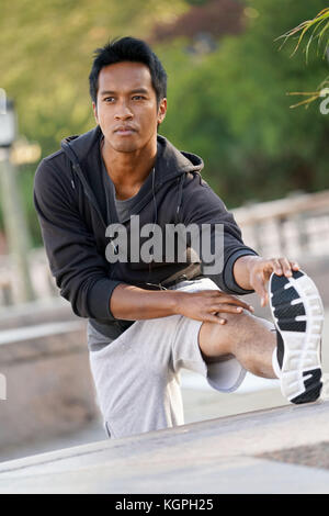 Asian guy stretching out after exercising Stock Photo