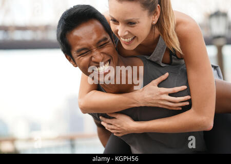 Man giving piggyback ride to girlfriend Stock Photo