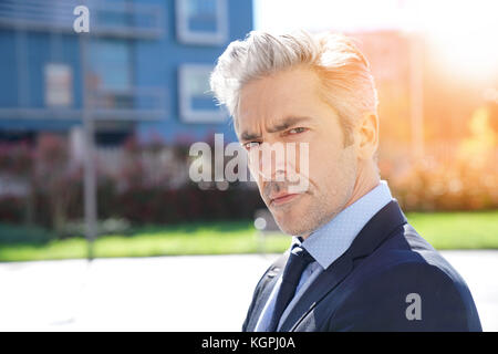 Portrait of mature businessman walking outside Stock Photo