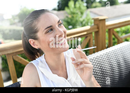 Portrait of smiling girl smoking a cigarette Stock Photo