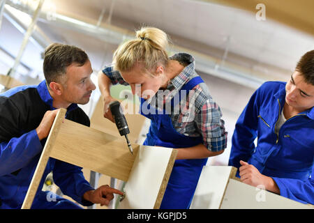 Carpenter with students in workshop assembling wood Stock Photo