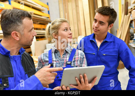 Carpentry teacher using tablet to train apprentice Stock Photo
