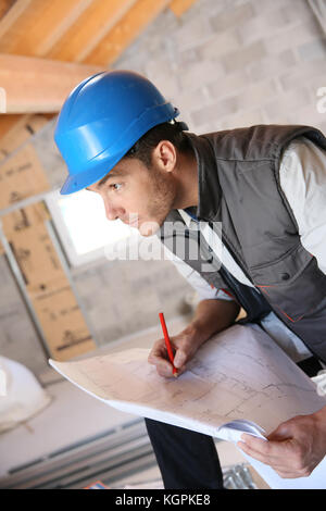 Construction manager on site reading blueprint Stock Photo