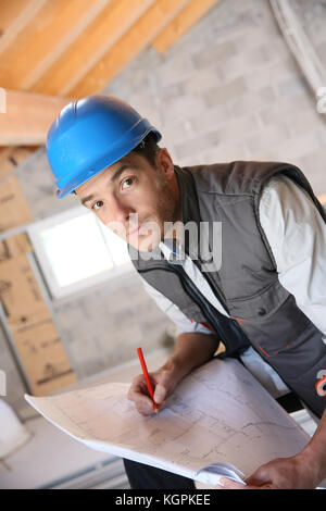 Construction manager on site reading blueprint Stock Photo