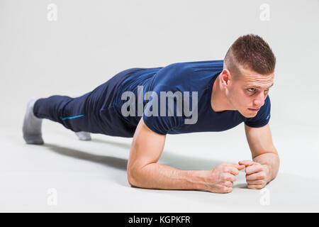 Studio shot image of young man who is doing push-ups. Stock Photo