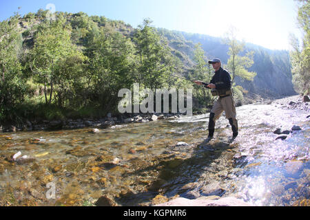 Fisherman using flyfishing rod in beautiful river Stock Photo