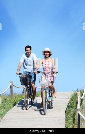 Couple riding bicycles in summertime Stock Photo