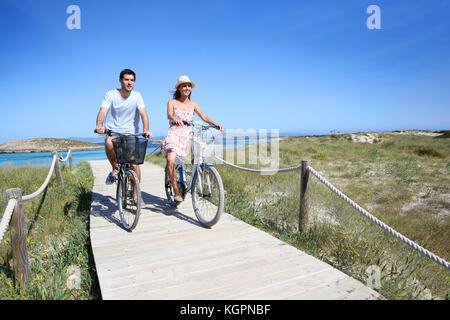 Couple riding bicycles in summertime Stock Photo